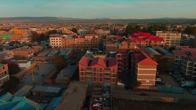 Aerial view of a vibrant African city Nairobi  at sunset, showcasing the unique architecture and urban landscape. The warm golden light casts long shadows.