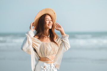 Happy young asian woman with freedom on the sea beach at golden sunset, Female tourist on seaside summer vacation