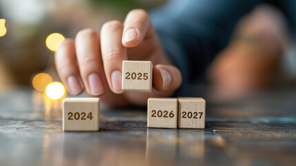 Planning for the Future: Hand Adjusting Year 2025 on Wooden Blocks