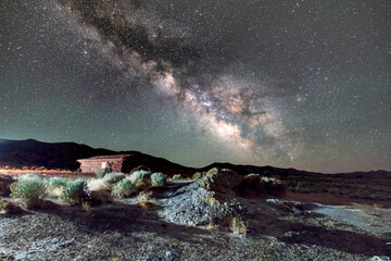 Desert landscape under the Milky Way and an old west cabin