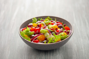 Easy vegetarian salad of fresh cucumber, tomato, sweet pepper,  onion  with pomegranate seeds. Healthy food.
