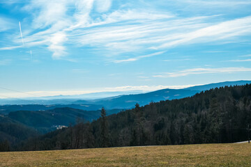 Alpine meadow in West Styrian highland in Voitsberg, Styria, Austria. Hiking in remote landscape of soft hills and forest in spring. Scenic view of idyllic mountains of Lavanttal Alps. Wanderlust