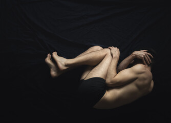 Man laying in fear, covering his face