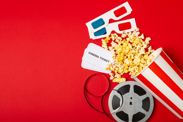 Tasty popcorn in buckets and cold cola drinks with cinema tickets, movie clapper and 3D eyeglasses...