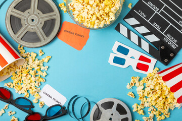 Tasty popcorn in buckets and cold cola drinks with cinema tickets, movie clapper and 3D eyeglasses...