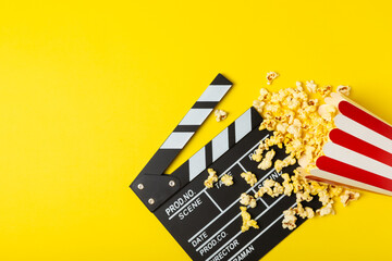 Tasty popcorn in buckets and cold cola drinks with cinema tickets, movie clapper and 3D eyeglasses...