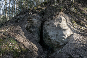 landscape with sandstone rock outcrop and cave, devil's cave near Vaidavmuiza, Valmiera county, Latvia