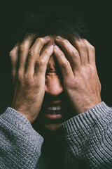 Stress, screaming and man in dark studio with hands on face in fear, nightmare and mental health...