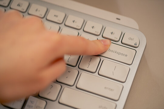 close-up female young hands pressing the backspace button on the keyboard office device nude manicure professional keyboard