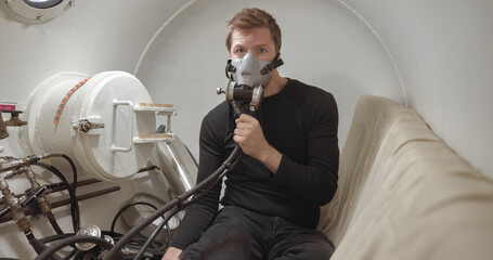 Military man receiving treatment in industrial hyperbaric chamber