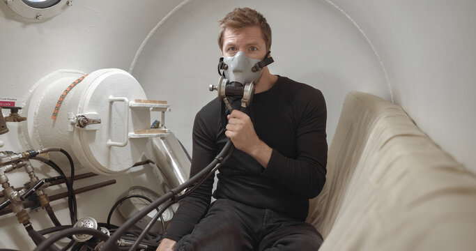 Military man receiving treatment in industrial hyperbaric chamber