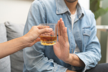 Alcoholism, depressed asian young man refuse, push out alcoholic beverage glass, drink whiskey,...