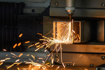 Close up scene the fiber laser cutting machine cut the square shape stainless steel tube with...