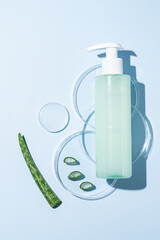 Petri dish with Aloe vera gel and soap and unlabeled pump bottle put on, a beaker of Aloe vera gel. Shampoo, cleanser, conditioner cosmetics packaging mockup of Aloe vera extract