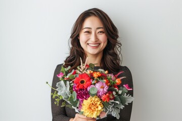 花束を持っている笑顔の日本人女性（母の日・結婚記念日・記念日・誕生日・デート）
