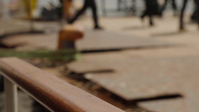 Woman disembarks ferry, steps onto busy seaport. Hand grips rail, backdrop of active dock, travelers move. Arrival scene, port life, daily commute. Female traveler in maritime city.