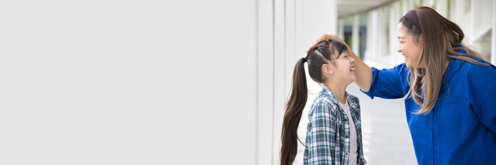 Happy Asian family with middle-aged mother patting her daughter’s head, concept of Happy Family...