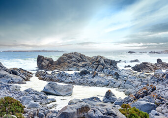 Coast, sea and waves landscape with horizon and rocks for peace, travel destination and holiday location. Beach, cloudy sky and ocean water for vacation environment, skyline and scenery in nature