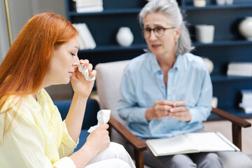 Young woman crying during therapy session with psychotherapist