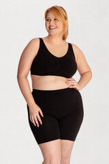 Obraz premium Portrait of a attractive young woman plus size in underwear model posing isolated on a white background mockup. White female, laughing and feeling confident. Clipping path. Body positivity - AI photo