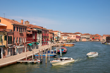 Obraz premium Panoramic view of small water channel on Murano island in city of Venice, Veneto, Italy, Europe. Venetian architectural landmarks and old houses facades along the man made water traffic corridor