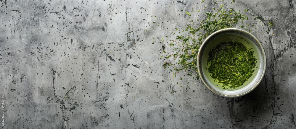 Poster top view of green sencha tea infused with floral and fruity notes set against a grey concrete backdr