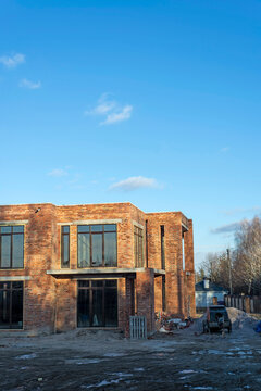 wall made of the red brick, windows and roof of modern private dwelling house against of sky