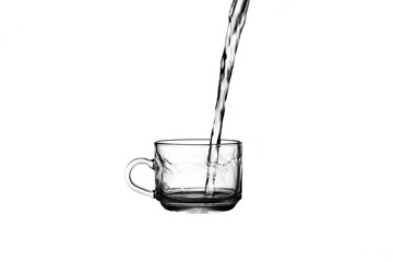 Water overflows from glass Water overflows from tea cup Pour water into a tea cup Tea cup on a white background.