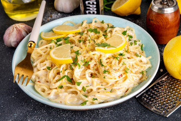 Homemade lemon pepper pasta, al limone spaghetti with creamy sauce with with lemon and pepper, copy space
