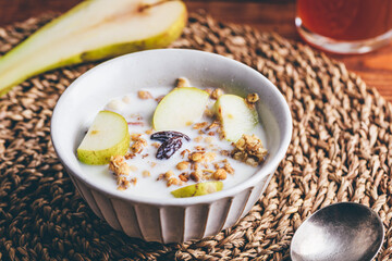 Homemade Granola with Fresh Pear and Milk in Vintage Bowl