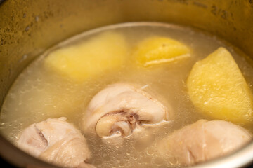 Pressure Cooker potato, meat, chicken  food during cooking. Cooking potatos in boiling water in saucepan electric multicooker pot. smart and healthy cooking in the modern kitchen by multi cooker.