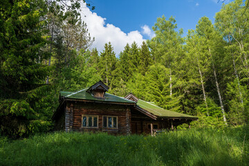 A wooden house with a green roof in a lake.