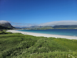 Tranquil Beach Day in Norway Surrounded by Lush Greenery and Majestic Mountains