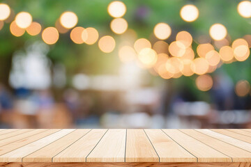 Empty wooden table  bokeh light background. Tables and chairs in the lobby of restaurant. Visitors to restaurant for dinner. Cozy bokeh lightening. Beautiful bright interior. Blurred bokeh basic backg