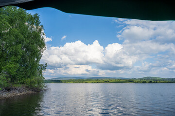 White puffy clouds and blue sky above Vlasina Lake. White cumulus clouds and a blue sky with sun...