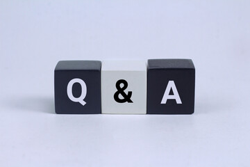 Q and A written on black and white cubes on the gray background. business.