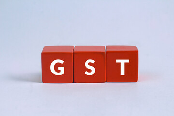 GST word Written on red wooden cubes on gray background