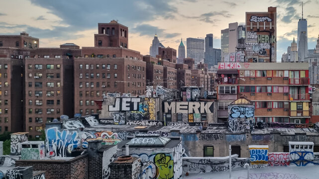 Captivating urban skyline showcasing modern architecture in New York The lower buildings are completely covered with colorful graffiti. Modern form of expression. Tall skyscrapers in the back.