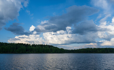 White puffy clouds and blue sky above Vlasina Lake. White cumulus clouds and a blue sky with sun...