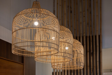 Three lamps with a woven design hanging from the ceiling