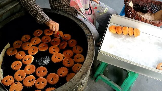 Footage of Baker Removing Freshly Baked Khanom Farang Kudeejeen Cupcakes from the Molds, a Famous Portuguese Influenced Cupcake in Thailand