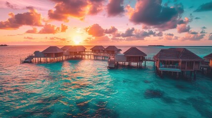 Stunning overwater bungalow resort in the Maldives, with crystal-clear turquoise waters and a vibrant sunset.