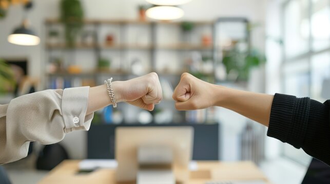 Business partners fist bumping in a startup office, celebrating a successful business milestone isolated white background 
