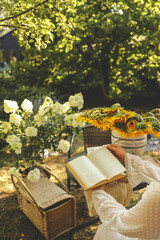 Girl reading a book in the garden, good summer morning concept