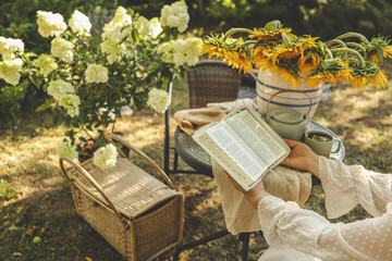Girl with Bible in hands in the morning in the garden, prayer and worship