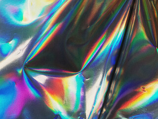 Fototapeta premium Holographic iridescent surface wrinkled foil. Real Hologram Abstract trendy Background of wrinkled glossy foil 80s 90s texture with Wrinkled vaporwave spectrum wavy noise grainy dust multiple colors
