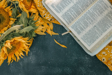 Bible and sunflowers top view on black background © shine.graphics