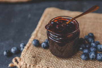 Delicious organic blueberry jam on dark background