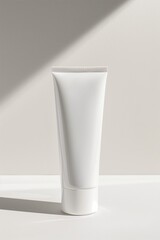 Minimalistic white cosmetic tube on a light background with shadow.