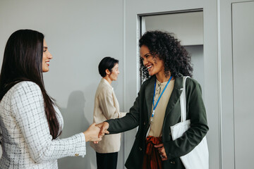 Friendly coworker farewell handshake at a corporate event